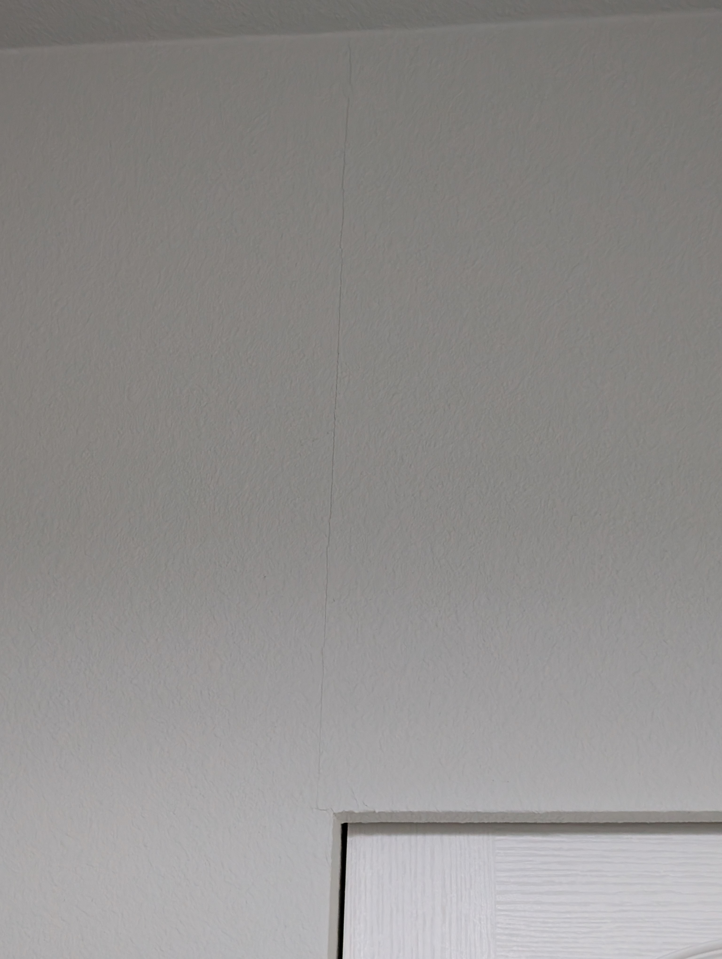 A vertical hairline crack is visible on the wall surface in the master bedroom.