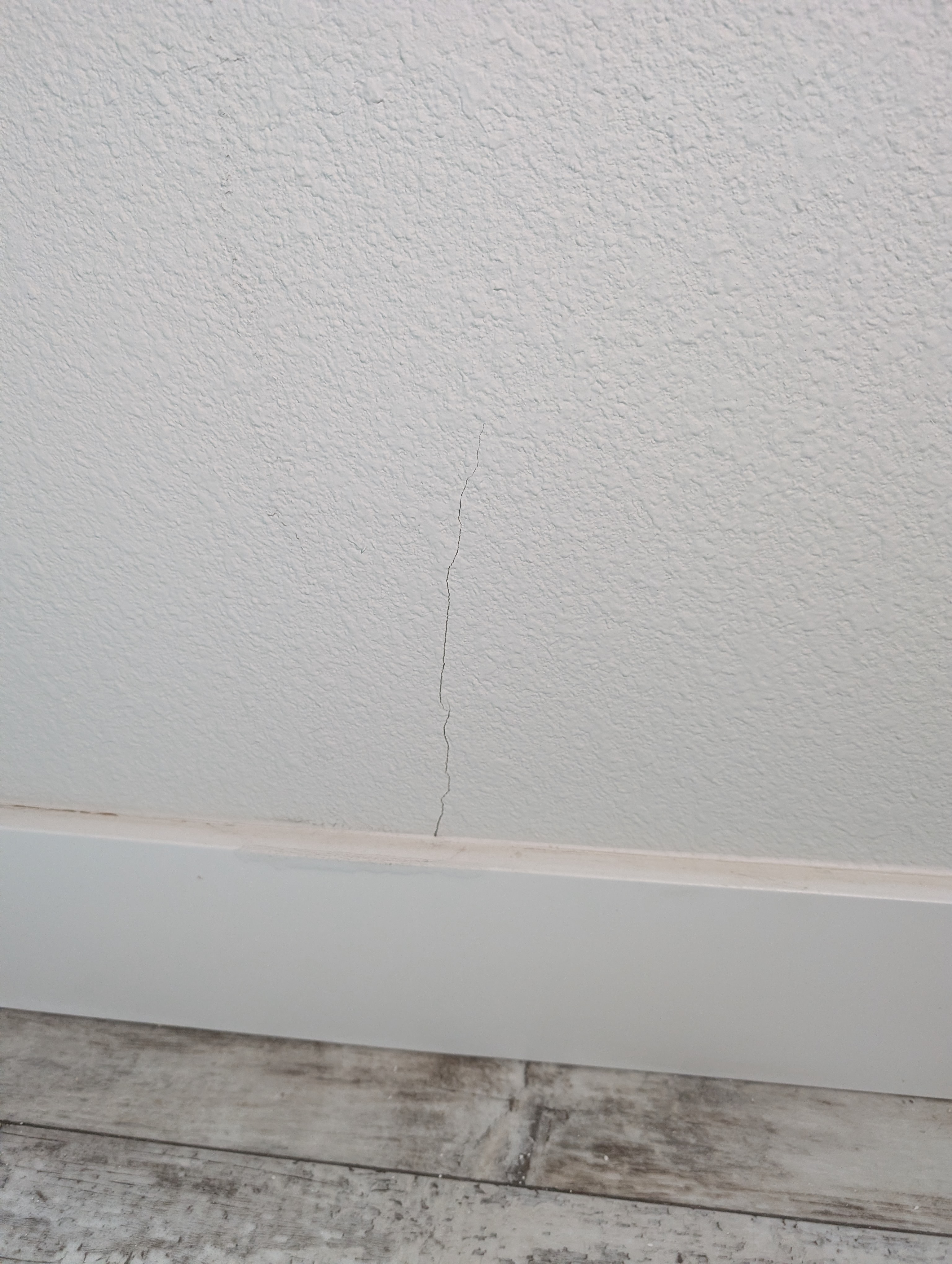 A vertical wall crack is visible in the bedroom adjacent to the master bedroom.