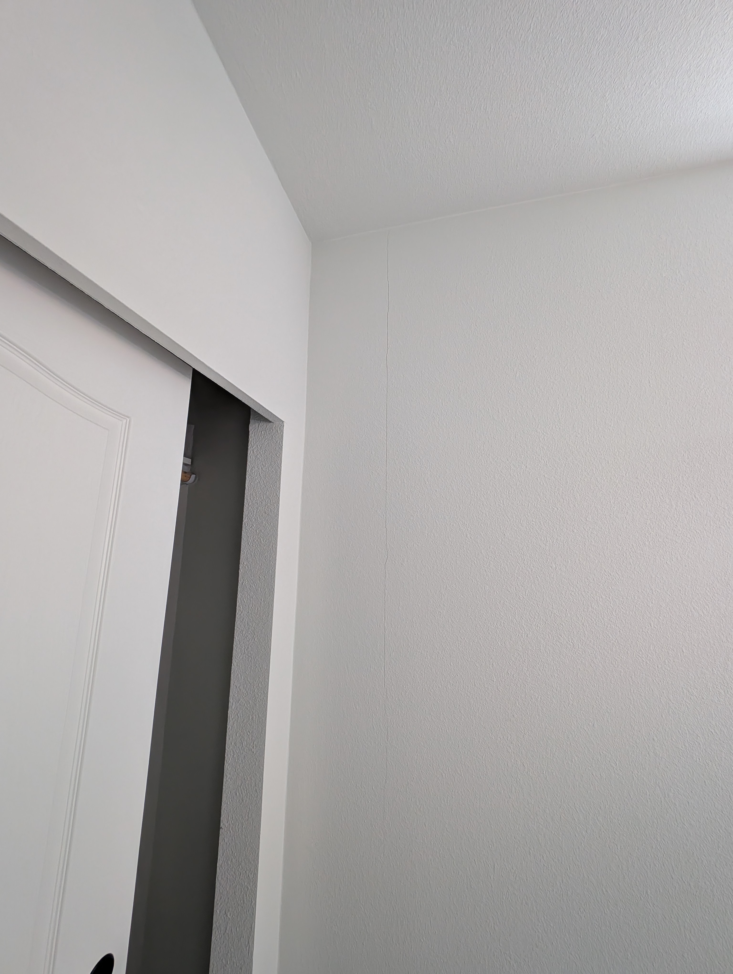 A crack extends outward from the corner joint of the wall in Bathroom 2.