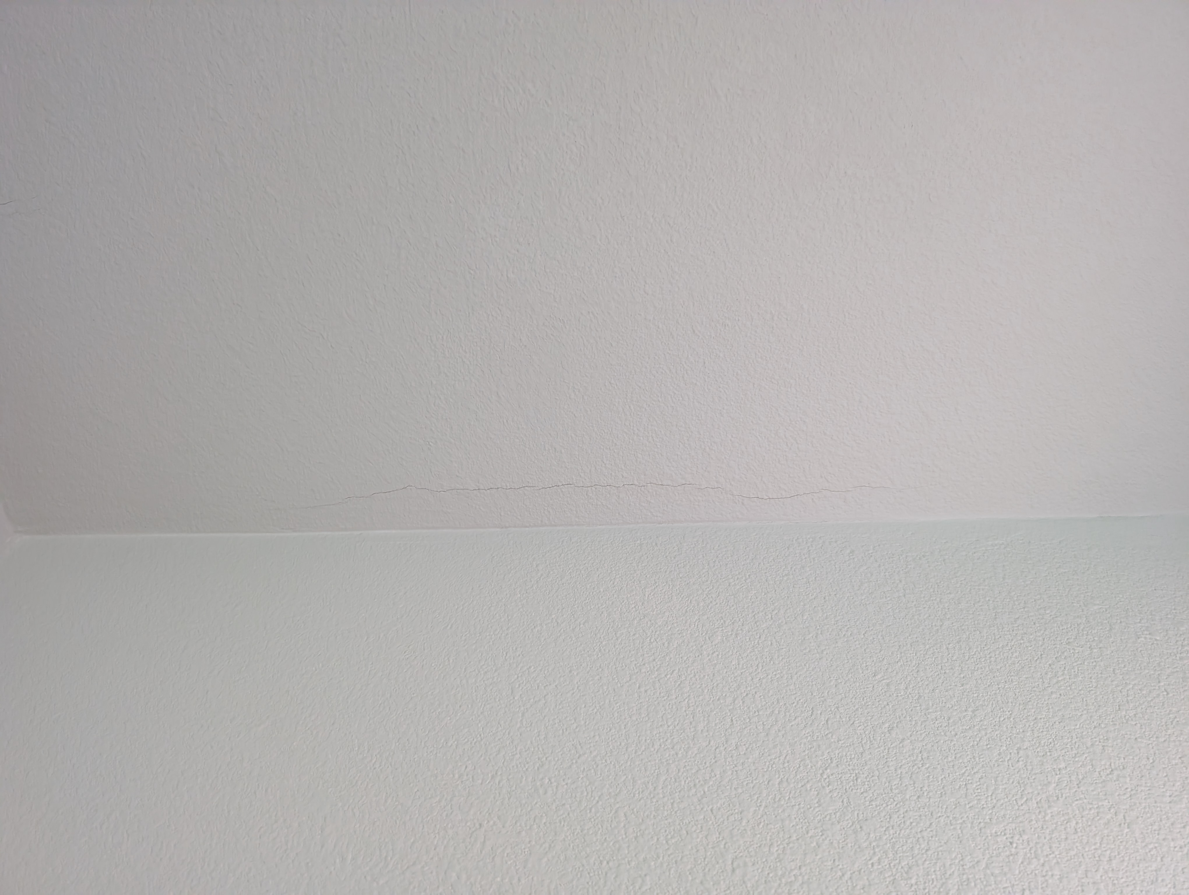 A vertical wall crack is visible in the laundry room under night lighting.