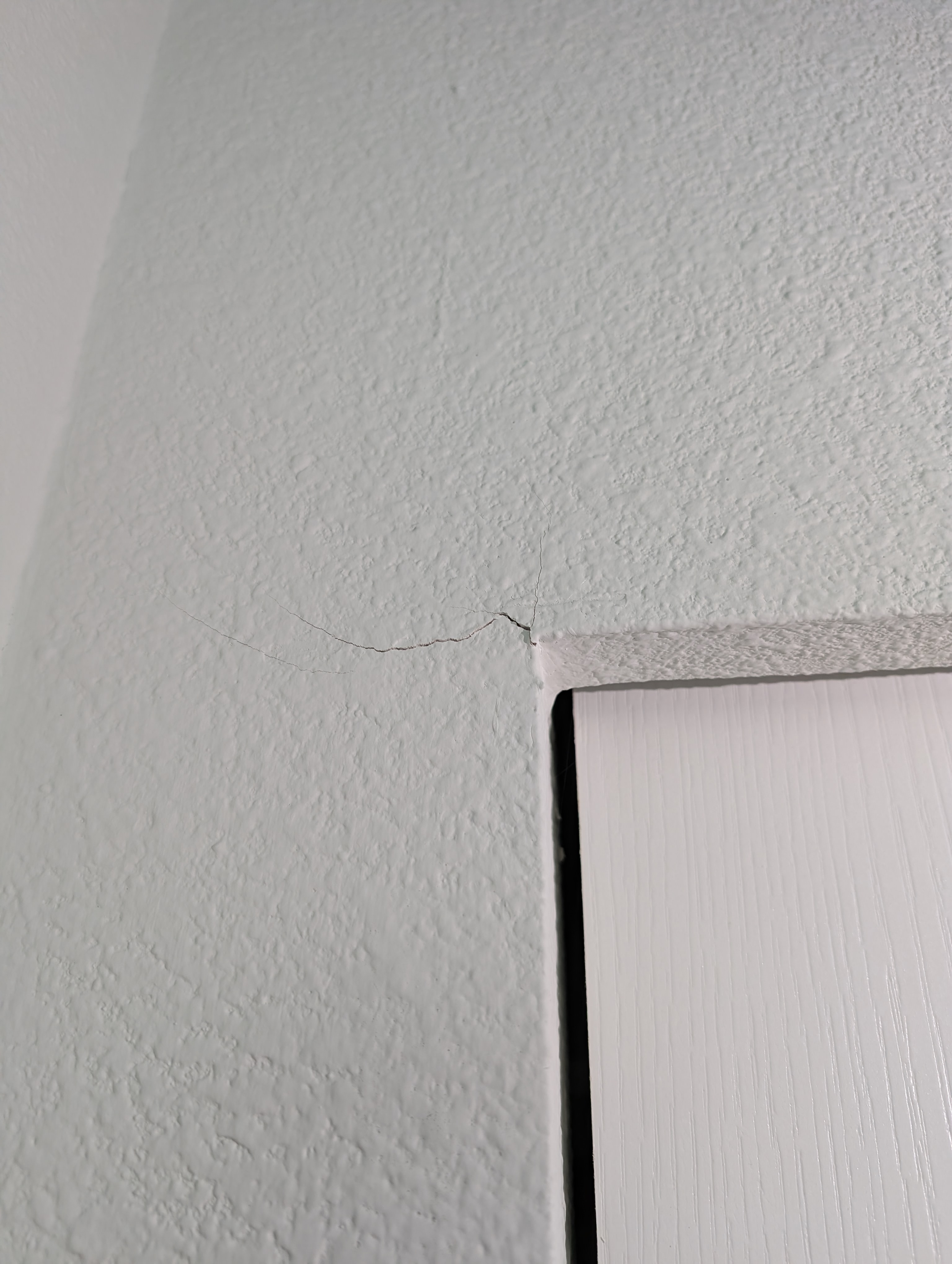 A branching crack pattern is visible on the laundry room wall.