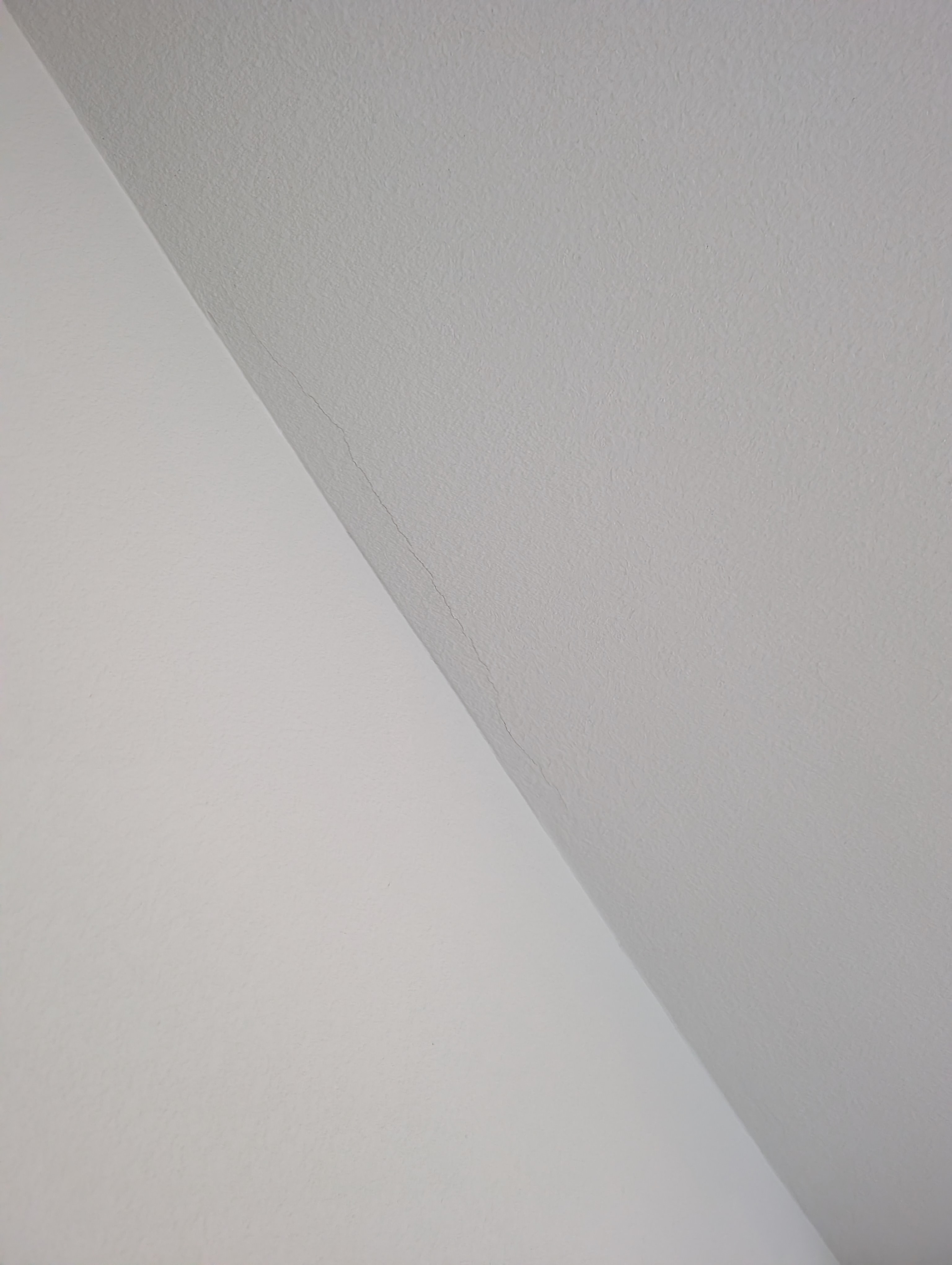 A vertical crack extends downward from the ceiling in the laundry room.